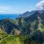 pointed mountains covered with greenery under a blue sky