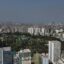 An aerial view of Lima City filled with sky-rise buildings and trees.