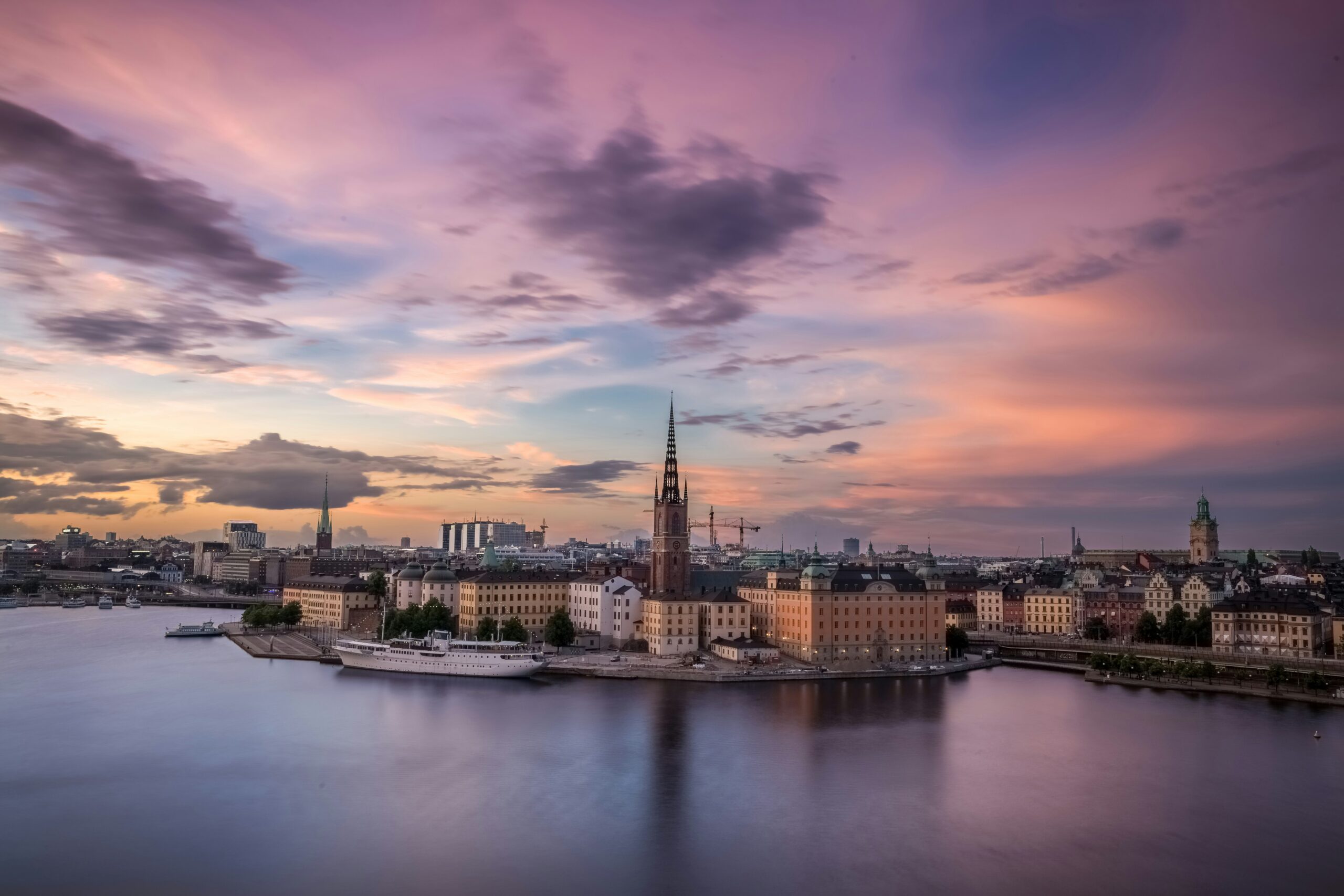 the waterways and ornate buildings of Stockholm under a brilliantly purple sunset sky