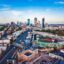 Aerial view of downtown Boston at sunset, featuring Fenway Park, the Charles River, and the Prudential Tower in the skyline. Major highways and city streets are visible, highlighting the accessibility and convenience of a Boston car service for navigating the urban landscape.