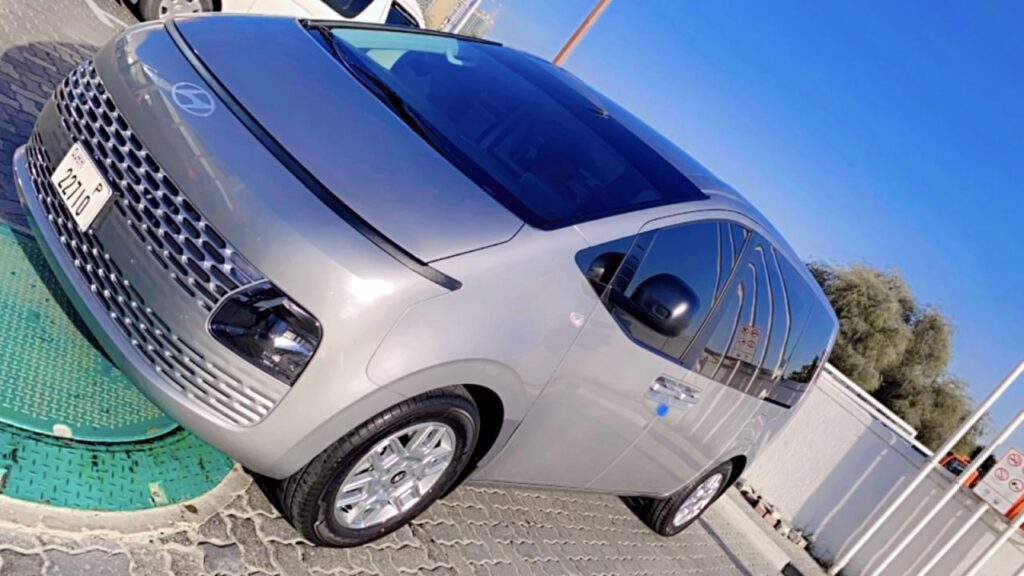 A silver Hyundai van parked in a sunny lot with a clear blue sky, used as an airport taxi Dubai passengers choose for group rides and modern comfort.