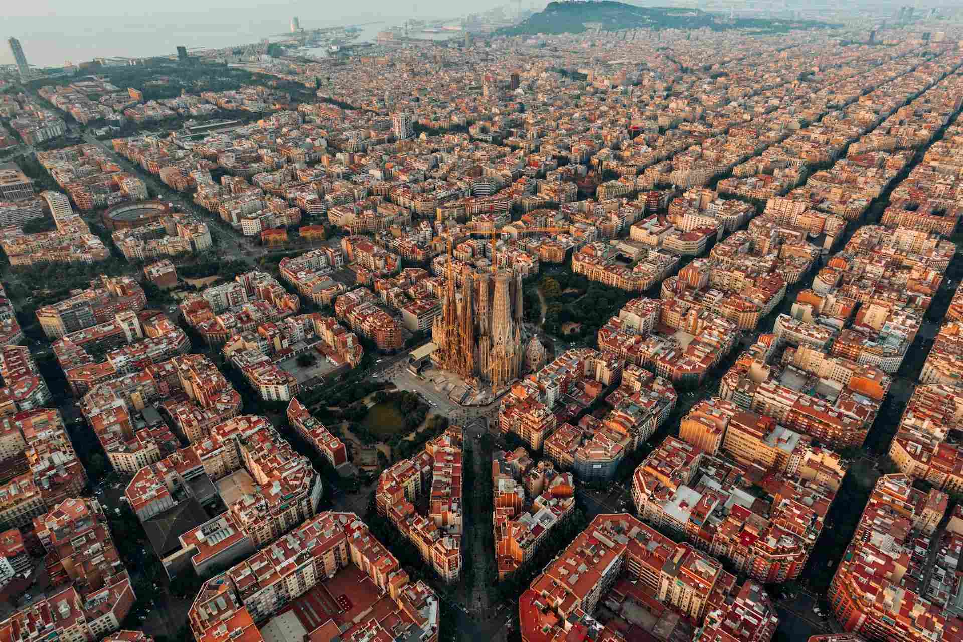 Aerial view of Barcelona city, with buildings in neat rows and blue skies above.