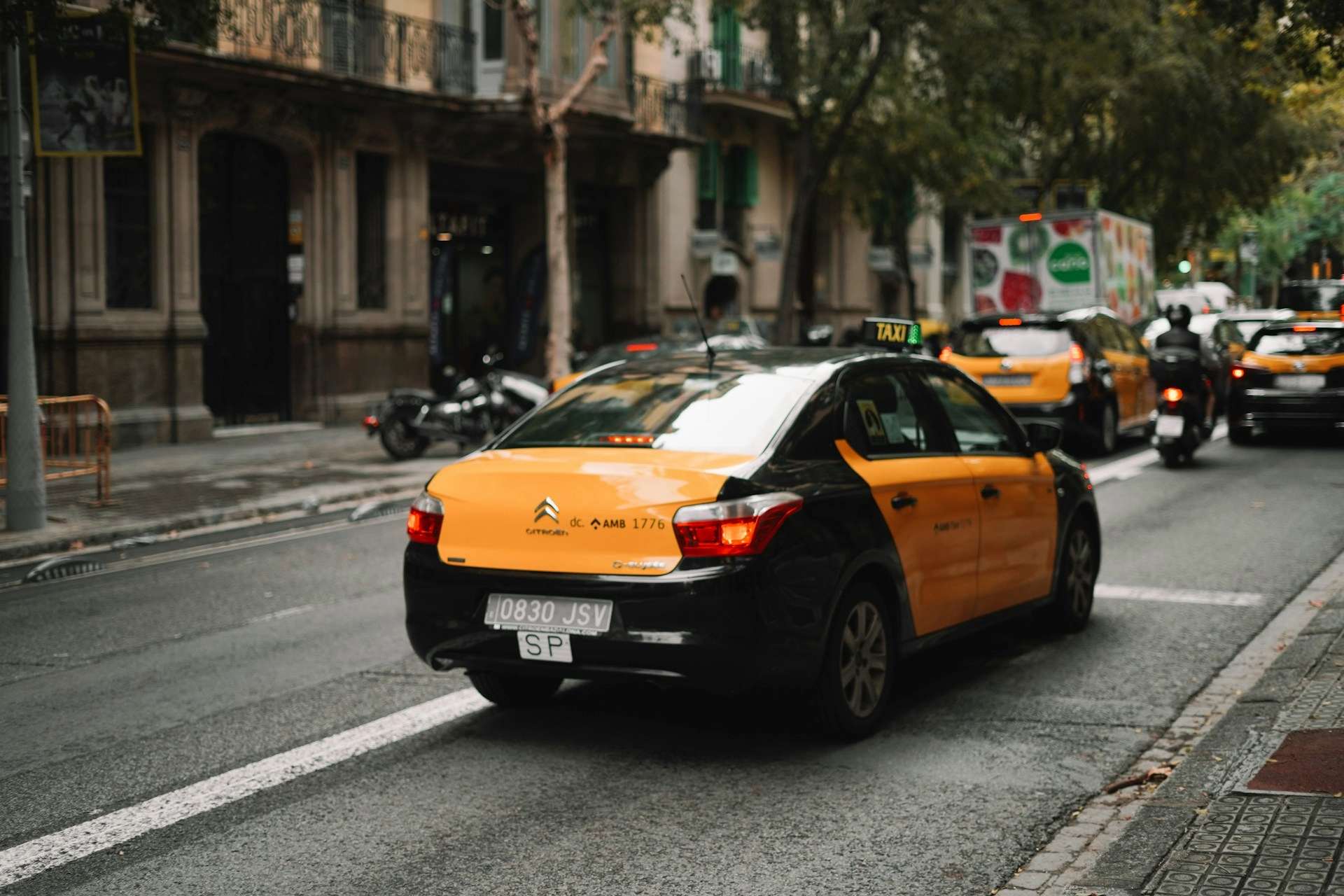 barcelona-taxi A black and yellow Barcelona taxi driving on a road in central Barcelona.