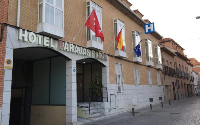 The front facade of Hotel Bajaras in Madrid, Spain. It is lined with flags.