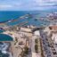 Aerial view of Civitavecchia Port, with a large body of water to the left, and