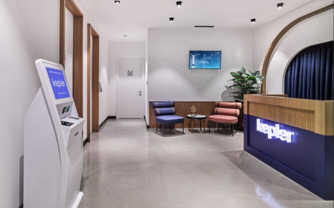 A blue and wooden counter with a neon sign in a room with a sofa and a touch screen