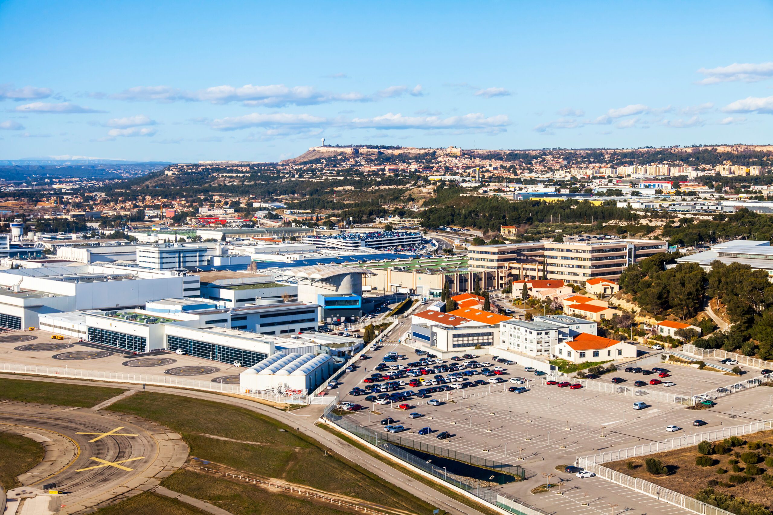 aerial view of a multi-story airprot with many vehicles parked outside