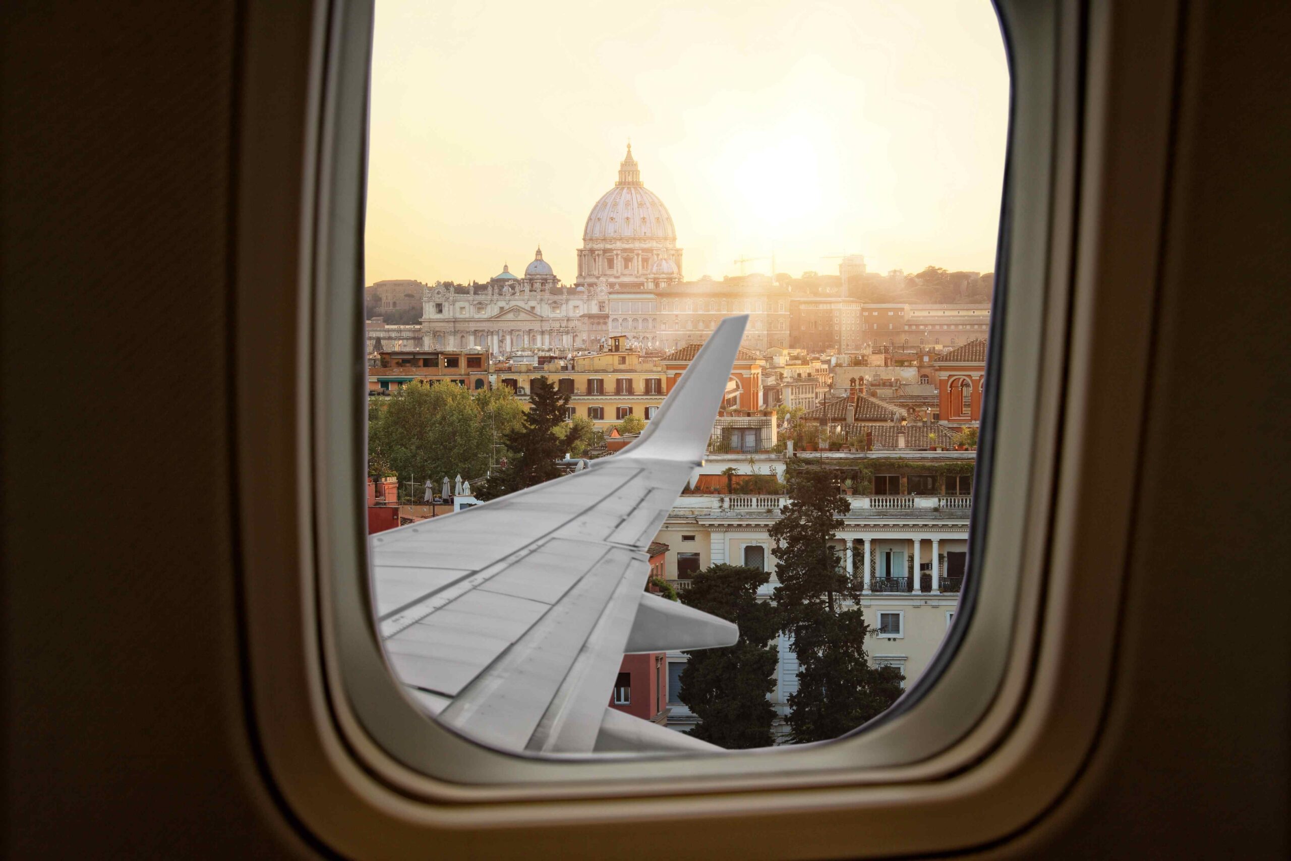 View of the basilica and a plane wing in central Rome from a plane window.