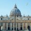 Front view of St Peter's Basilica in the Vatican City, with blue skies above.