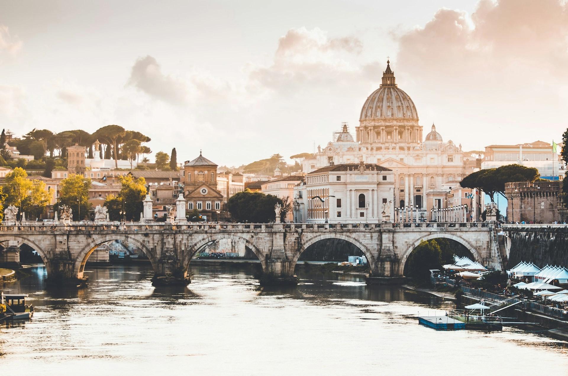 View of a bridge over a body of water in central Rome, with historical buildings in the background.