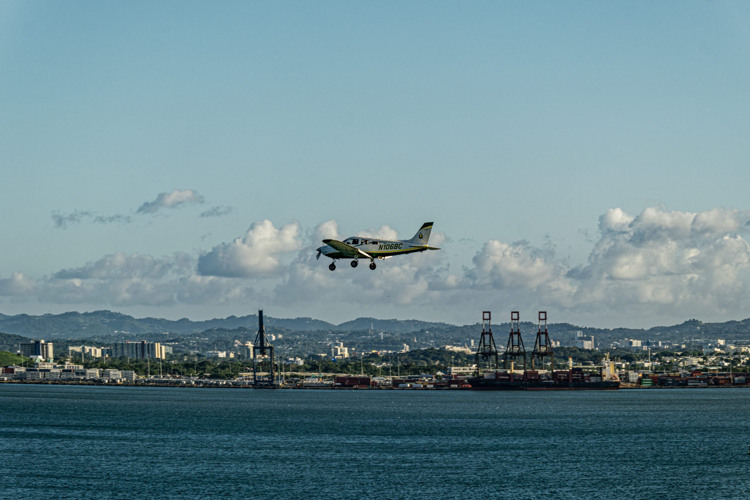 a plane is almost landing on a runway in front of blue terrain