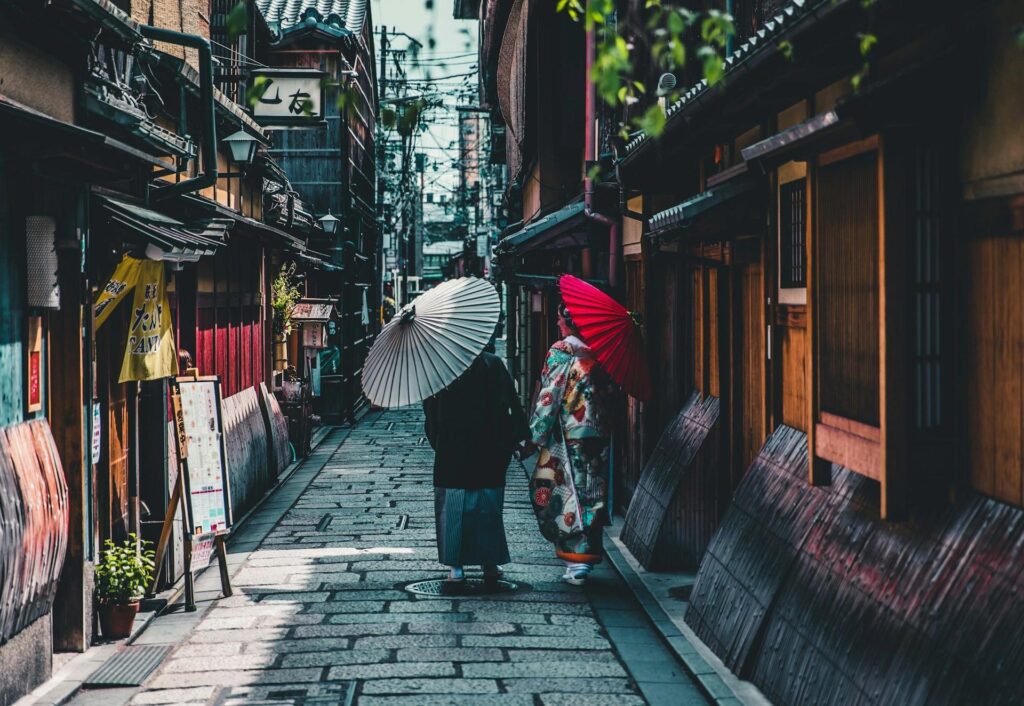 Two local women walking in the colorful streets of Kyoto, wearing traditional clothes.
