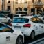 A queue of white Rome taxis on either side of a road in the city.