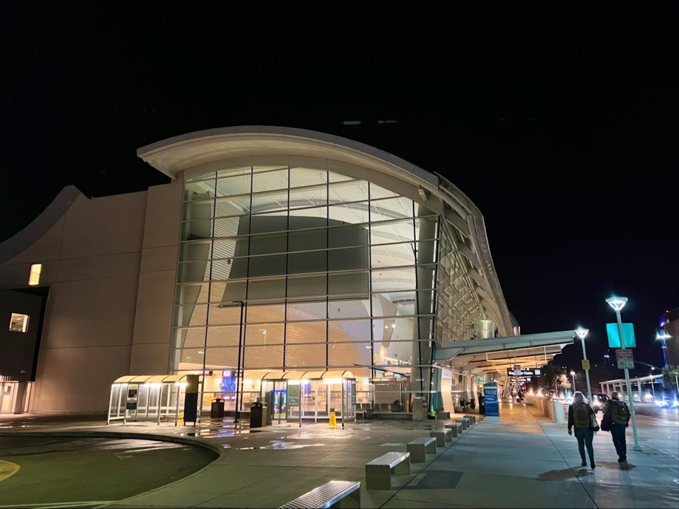 multi-story window pane at the front of an airport building at night
