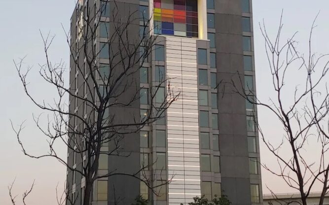 The tall gray Alt Hotel at Toronto Airport with two bare trees in front.