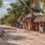 A sandy street on Holbox Island lined with palm trees, rustic wooden stalls, and bicycles, capturing the laid-back vibe travelers experience after taking transportation from Cancun Airport to Chiquila and catching the ferry to Holbox.