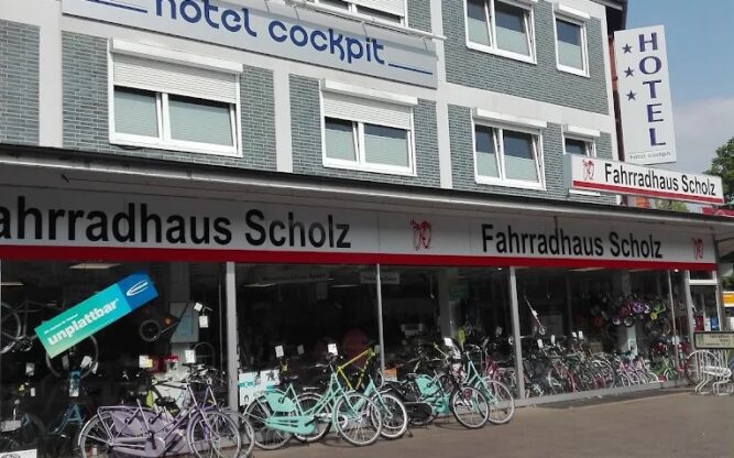 The grey upper level of the Hotel Cockpit with a bike store underneath.