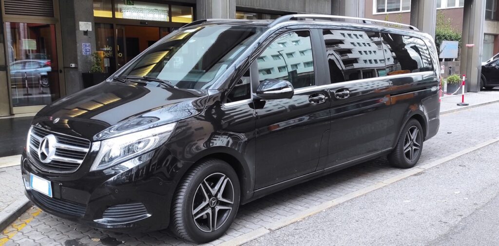 Side view of a black Venice Airport taxi minivan.