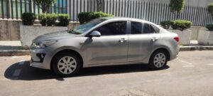A silver Cancun Airport taxi sedan parked on the side of a sunny street, featuring four doors, tinted windows, and compact styling; commonly used for private airport transfers from Cancun Airport.