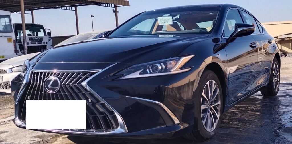 A sleek black Lexus sedan parked in a sunlit lot, commonly used as a premium taxi for Dubai Airport transfers.