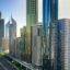 Morning view of Dubai’s skyscraper-lined Sheikh Zayed Road with metro tracks running alongside, illustrating a typical journey from Dubai Airport to Dubai’s bustling city center.