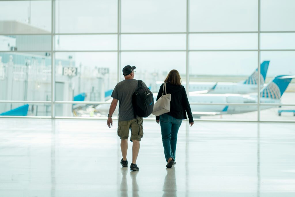 Passengers in transit walking inside a modern airport terminal during a stopover, ideal for tips on things to do during an Athens layover