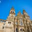 Ornate baroque facade of the Santiago de Compostela Cathedral under a clear blue sky, a popular landmark for pilgrims and tourists arriving via Santiago de Compostela Airport taxi for a visit to the historic Old Town.