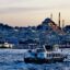 Evening view of Istanbul’s historic peninsula with the illuminated Süleymaniye Mosque and ferryboats crossing the Golden Horn, capturing the vibrant atmosphere travelers experience after taking the route from Istanbul Airport to city center.
