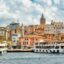 Colorful view of Istanbul's waterfront with passenger boats docked along the Bosphorus and the historic Galata Tower rising in the background—ideal arrival point for travelers taking a Sabiha Gokcen Airport taxi into the city.