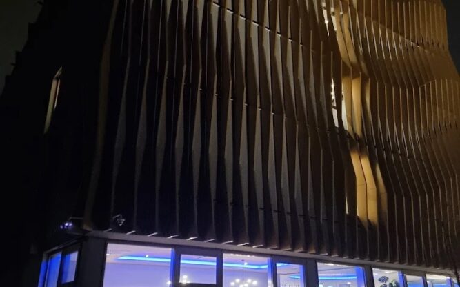 A view of the Leonardo Royal Hotel Cologne Airport at night with the lower level it up.
