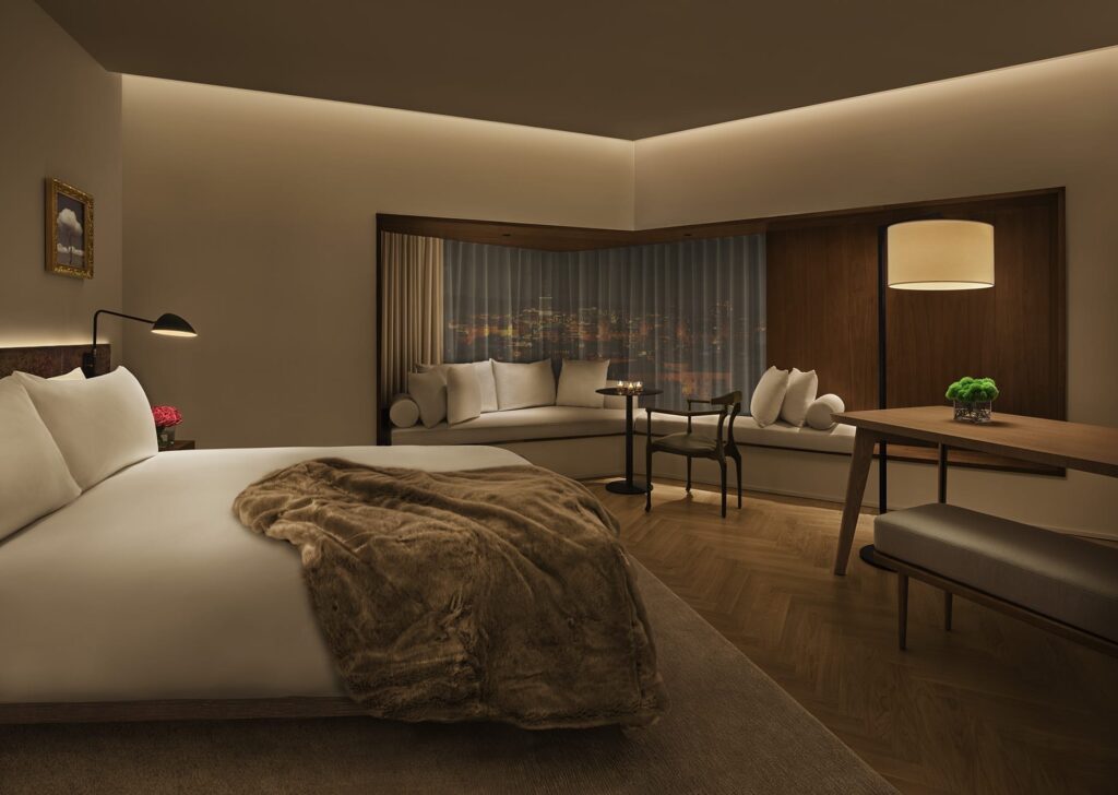 Room in the Barcelona Edition. Soft lighting and luxury bed with white sheets.