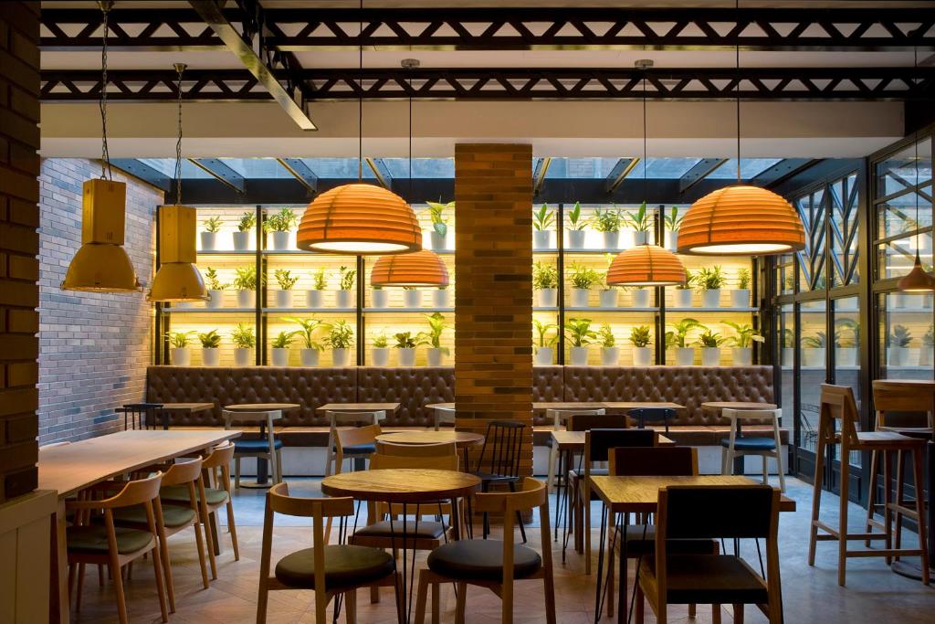 Sitting area of the bakery at Praktik Hotel. Hanging orange lights and a backlit bakery section. 