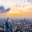 Bangkok cityscape under a bright yellow sunset and cloudy sky