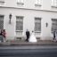 Bride and groom outside of a historical building in Budapest. People walking by.