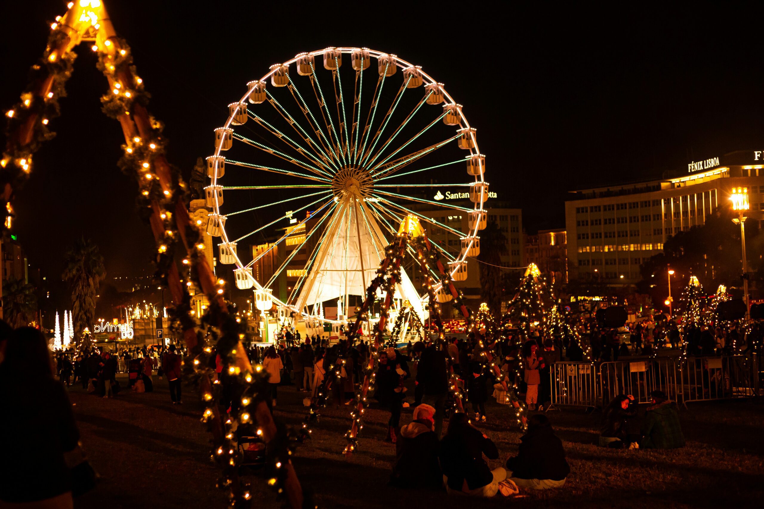 A Lisbon Christmas market with lots of glowing lights and a large ferris wheel.