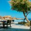 dining tables and chairs set up in the shade alongside one of Malta's beautiful beaches