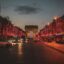 Champs Elysees with Christmas lights lining all the trees. Night time, so the red lights sparkle.