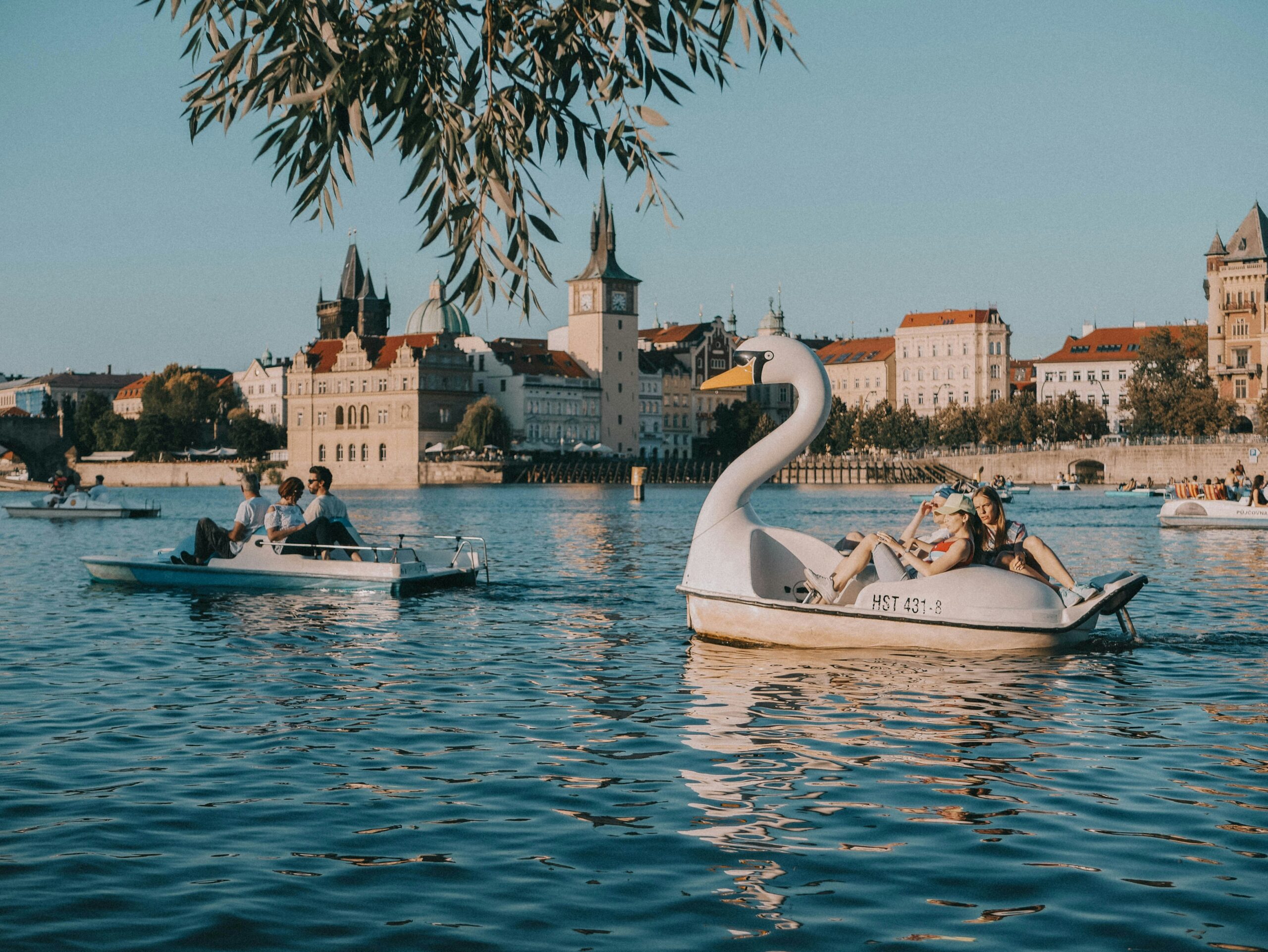 couples peddle two swan paddle boats on Prague's waterway