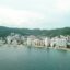 View of hotels along the Acapulco shoreline. A small beach and mountains in the background.