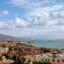 A view of Naples coastline filled with houses and a mountain in the background