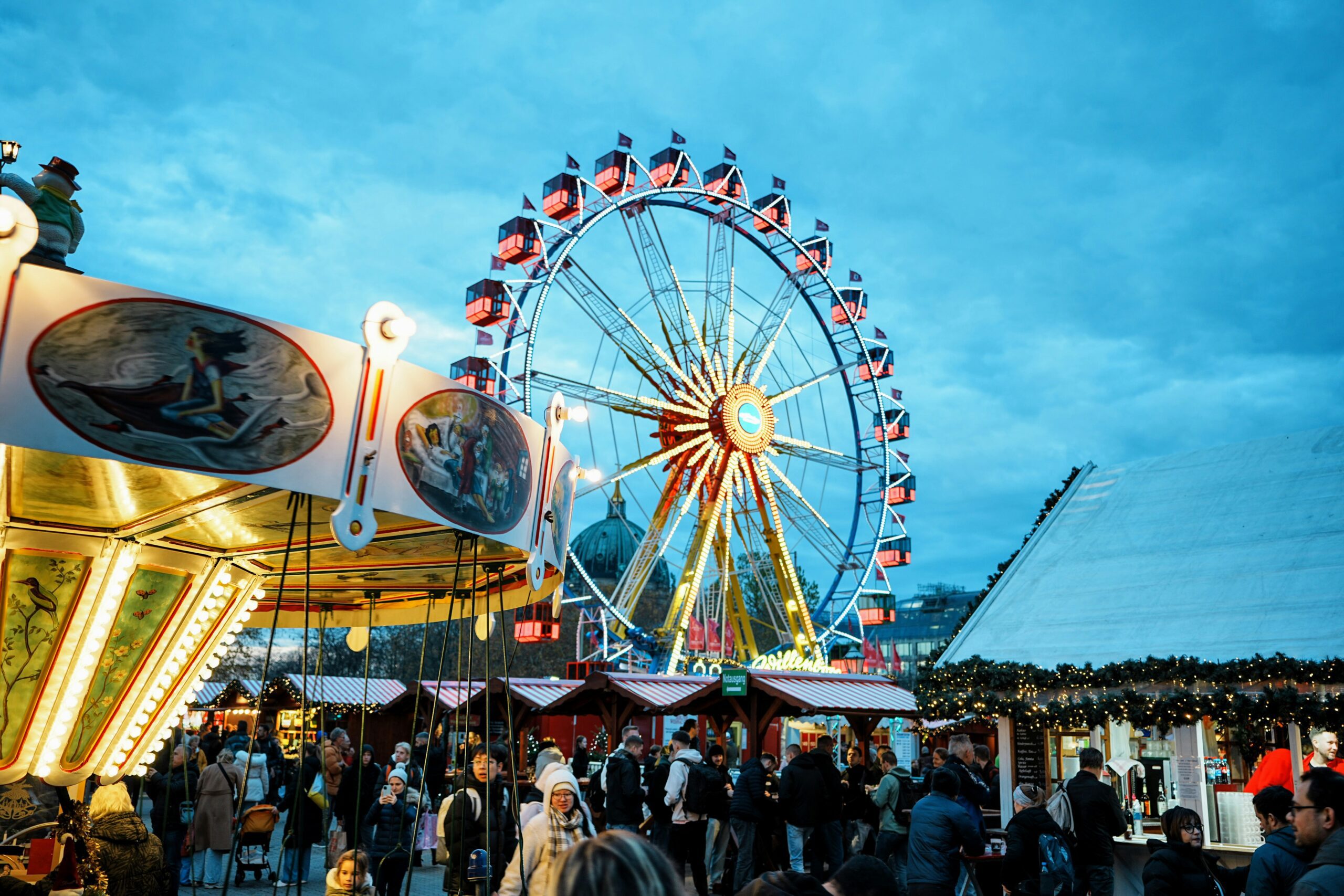 A Christmas market with a ferris wheel in the background