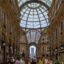 Crowds of people walking through a domed glass mall