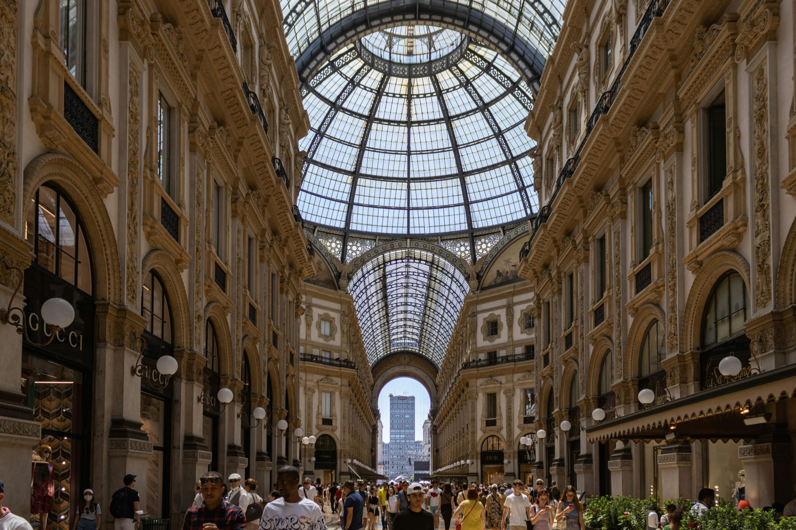 Crowds of people walking through a domed glass mall