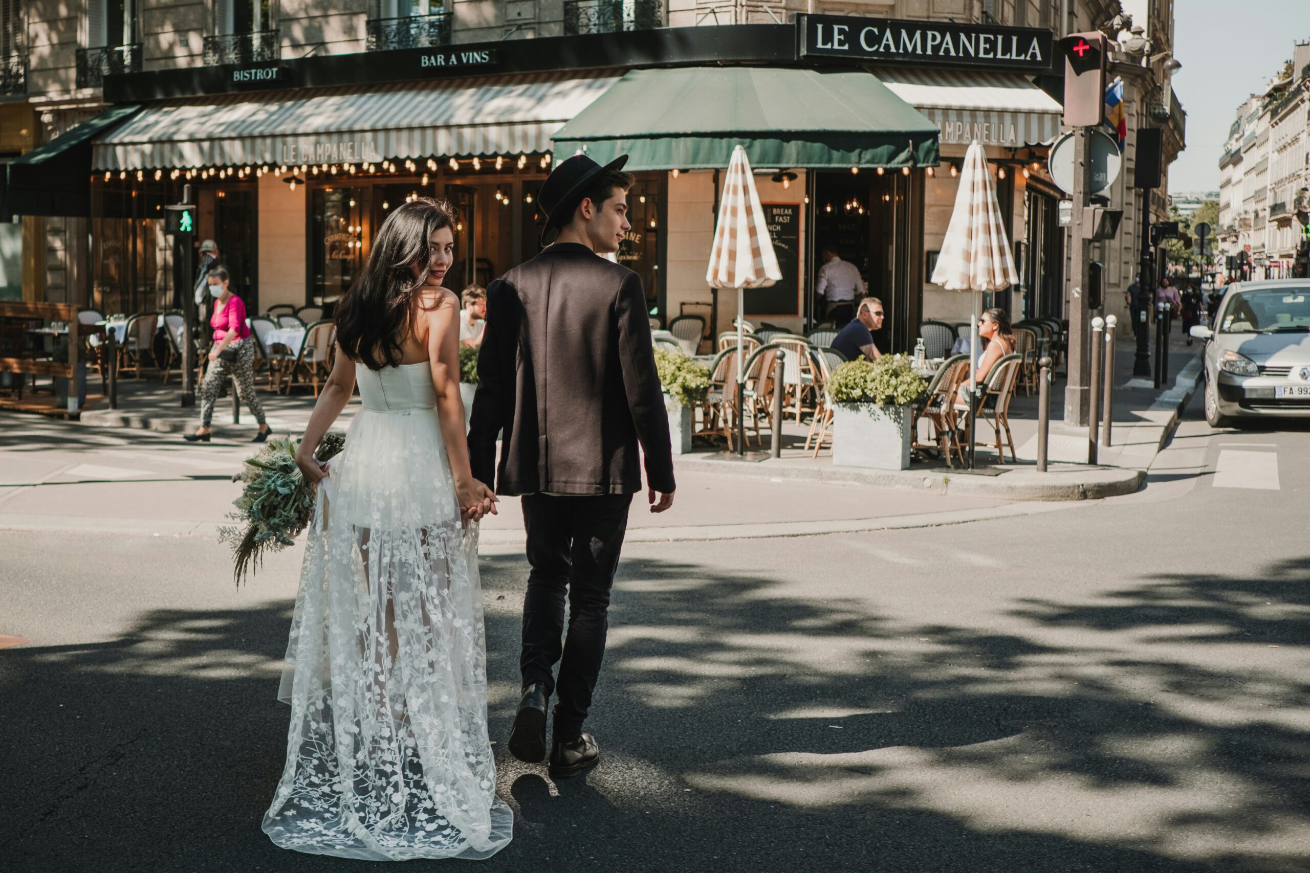 A married couple smiling back at the camera on the sunny streets of Barcelona