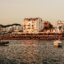 A view of the coastline in Ibiza with lots of people on the beach and boats in the water.