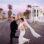 A married couple in a dress and suit crossing an empty street in downtown Las Vegas