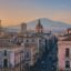 Panoramic sunset view of Catania city center with the Cathedral and Mount Etna in the background, a top location for travelers booking a Catania Airport taxi.