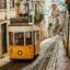Private airport transfer in Lisbon passing by the iconic yellow tram in the historic Alfama district