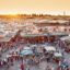 Busy Jemaa el-Fnaa square in Marrakech, Morocco, at sunset with traditional markets and crowds, a top location for travelers booking a Marrakech airport taxi.