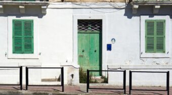 Malta Sliema street with traditional house and green shutters near Malta Airport route